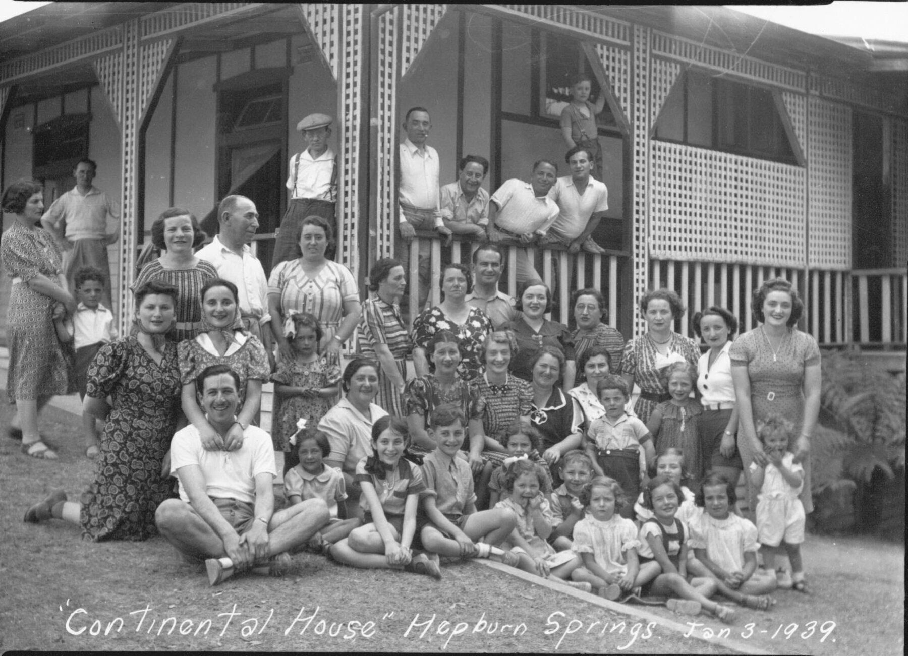 Around forty summer guests, adults and children, gathered on the lawn in front of the lattice verandah