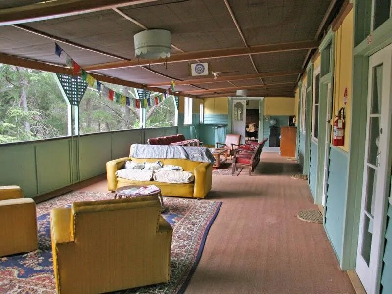 The sunroom with yellow armchairs and prayer flags