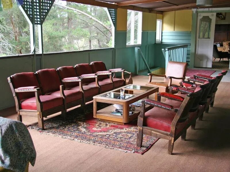 A row of red upholstered chairs around a glass coffee table