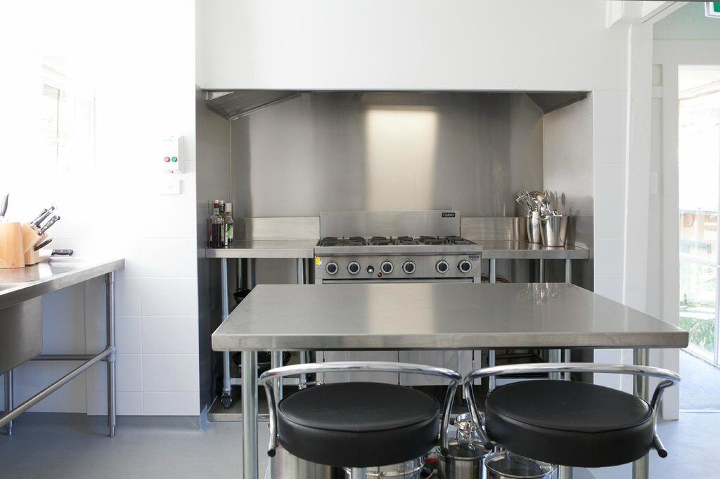 The stainless-steel commercial kitchen with a six-burner range