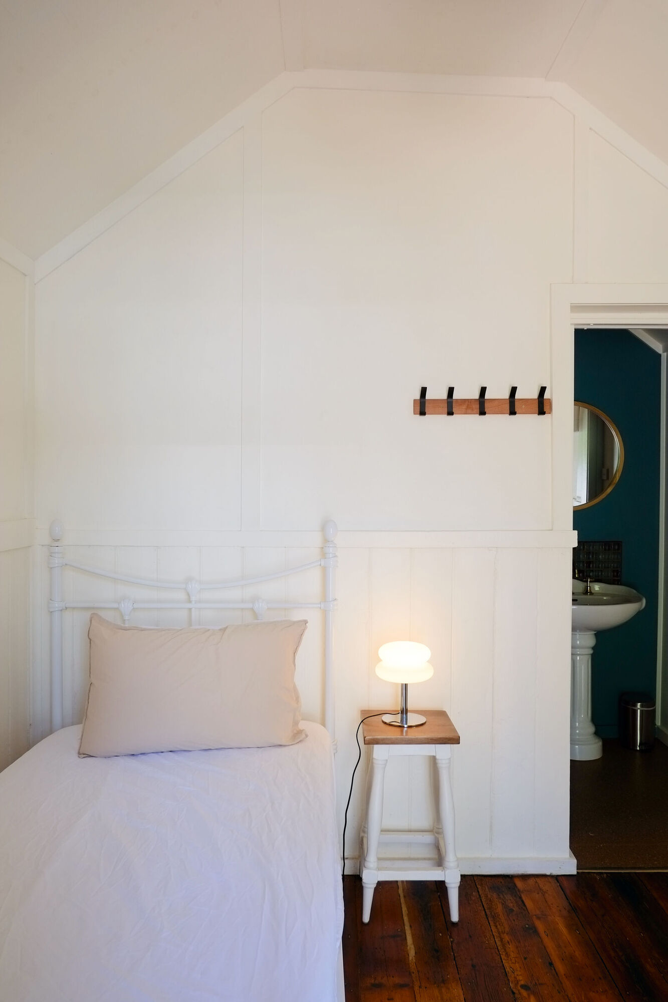 The Red Tent: a small green weatherboard studio with white trim and its door open